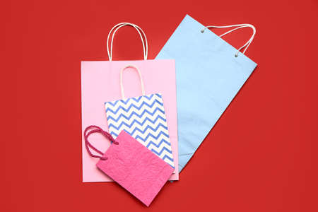Paper shopping bags on color background