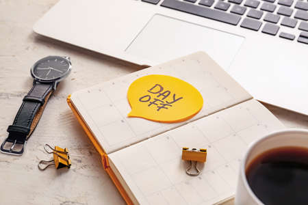 Notebook with text DAY OFF at workplaceの写真素材