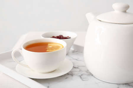 Cup of hot beverage, teapot and jam on tableの写真素材