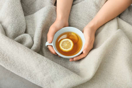 Woman with cup of hot tea at homeの写真素材