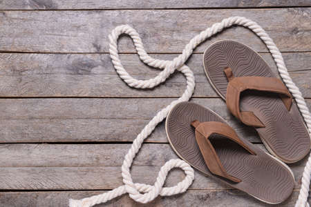 Stylish flip-flops on wooden backgroundの写真素材