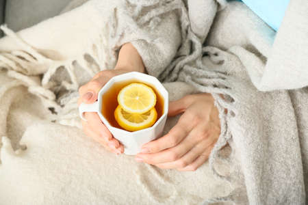 Woman with cup of hot tea at homeの写真素材