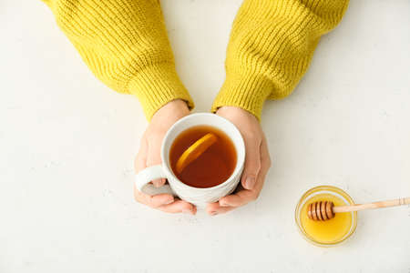 Woman with cup of hot tea at table