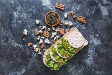 Plate with rice crispbreads, salad and sprouts on dark backgroundの写真素材
