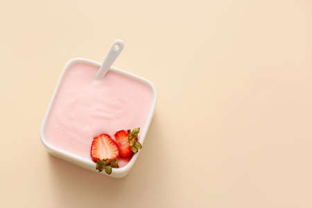 Bowl of strawberry yogurt on color backgroundの写真素材