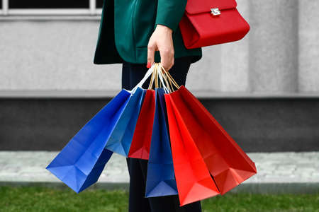 Beautiful young woman with shopping bags outdoors