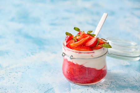 Jar of strawberry yogurt on color backgroundの写真素材