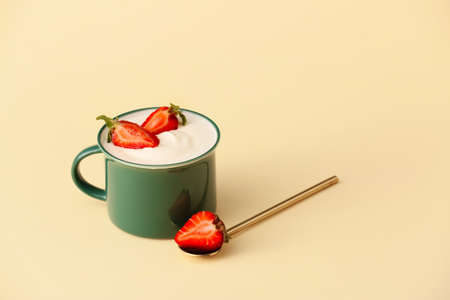 Cup of strawberry yogurt on color backgroundの写真素材