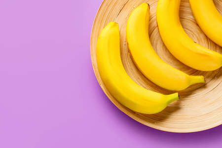 Plate with ripe bananas on color backgroundの写真素材