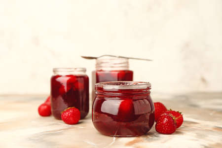 Jars of tasty strawberry jam on tableの写真素材