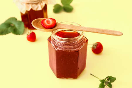 Jar of tasty strawberry jam on color backgroundの写真素材