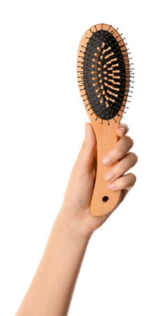 Woman hand and hair brush on white backgroundの写真素材