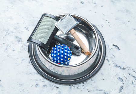 Pet bowl with toy and brushes on light backgroundの写真素材