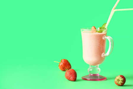 Cup of tasty strawberry smoothie on color backgroundの写真素材