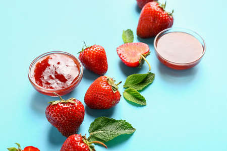 Bowls of tasty strawberry jam on color backgroundの写真素材