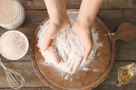 Woman with rice flour at table, top viewの写真素材
