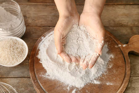 Woman with rice flour at table, top viewの写真素材