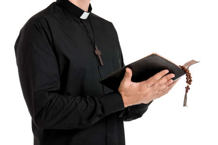 Handsome priest with Bible on white background