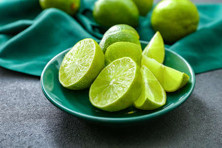 Plate with fresh cut limes on table