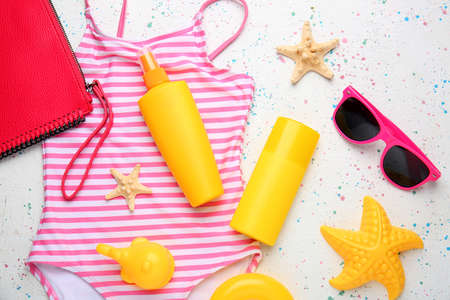 Sunscreen cream with beach accessories on white background