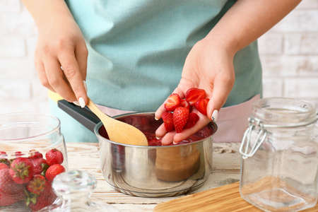 Woman making sweet strawberry jam in kitchen, closeupの写真素材