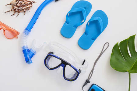Set of beach accessories with snorkeling mask and flip-flops on white background
