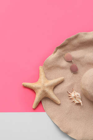 Set of wicker hat and seashells on color backgroundの写真素材
