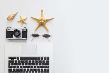 Set of beach accessories with laptop and photo camera on white background. Concept of freelancingの写真素材