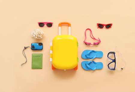 Suitcase with beach accessories on color backgroundの写真素材