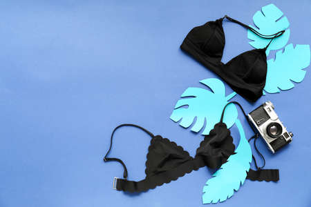 Composition with swimsuits and photo camera on color backgroundの写真素材