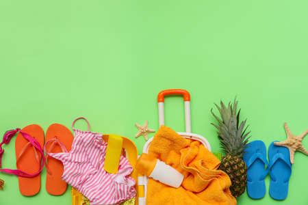 Suitcase with beach accessories on color backgroundの写真素材