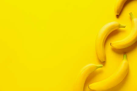 Ripe bananas on color backgroundの写真素材