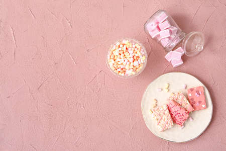 Plate with crispy rice bars and marshmallow on color background