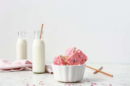 Bowl with crispy rice bars and milk on table