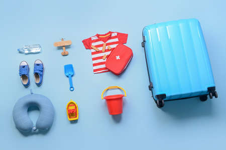 Flat lay composition with little boy beach accessories and first aid kit on color background. Travel conceptの写真素材