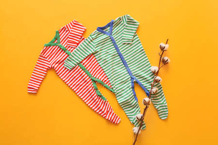 Cotton baby clothes on color background