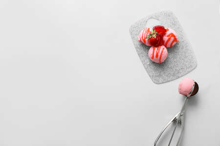 Board with tasty strawberry ice cream on white background