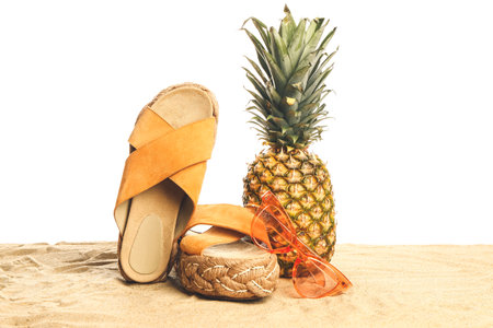 Beach accessories on sand against white backgroundの写真素材
