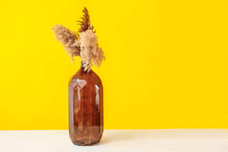 Beautiful vase with floral decor on table against color backgroundの写真素材