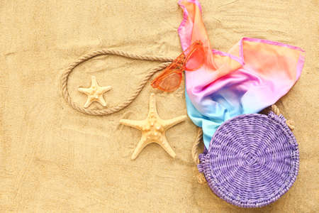Beach accessories on sand background