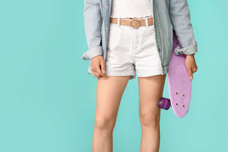 Beautiful young woman in jeans clothes on color background
