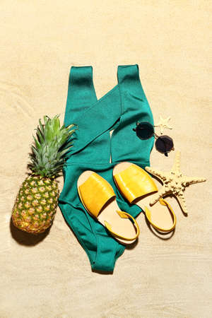 Beach accessories on sand background