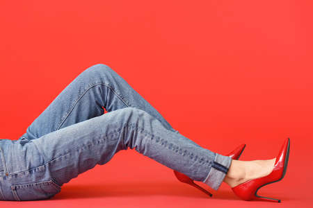 Beautiful young woman in jeans on color backgroundの写真素材