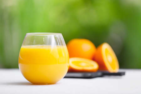 Glass of orange fruit on table outdoorsの写真素材