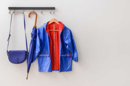 Raincoat, umbrella and bag in hallwayの写真素材