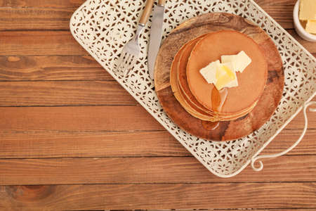 Tasty pancakes with butter and honey on tableの写真素材