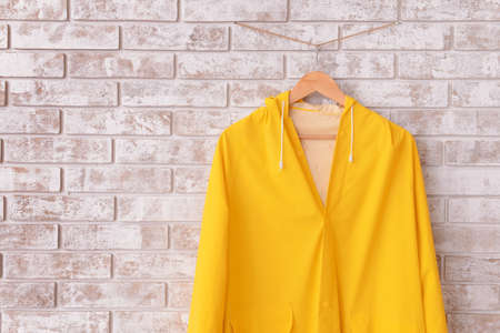 Raincoat hanging on brick wall in hallwayの写真素材