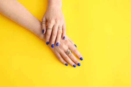 Hands with beautiful manicure on color backgroundの写真素材