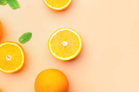Juicy orange fruit with mint on color backgroundの写真素材