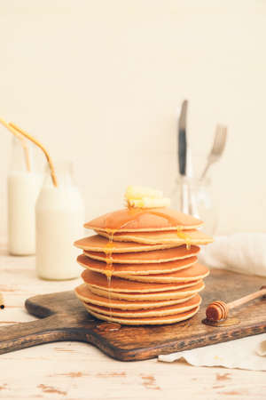 Tasty pancakes with butter and honey on tableの写真素材